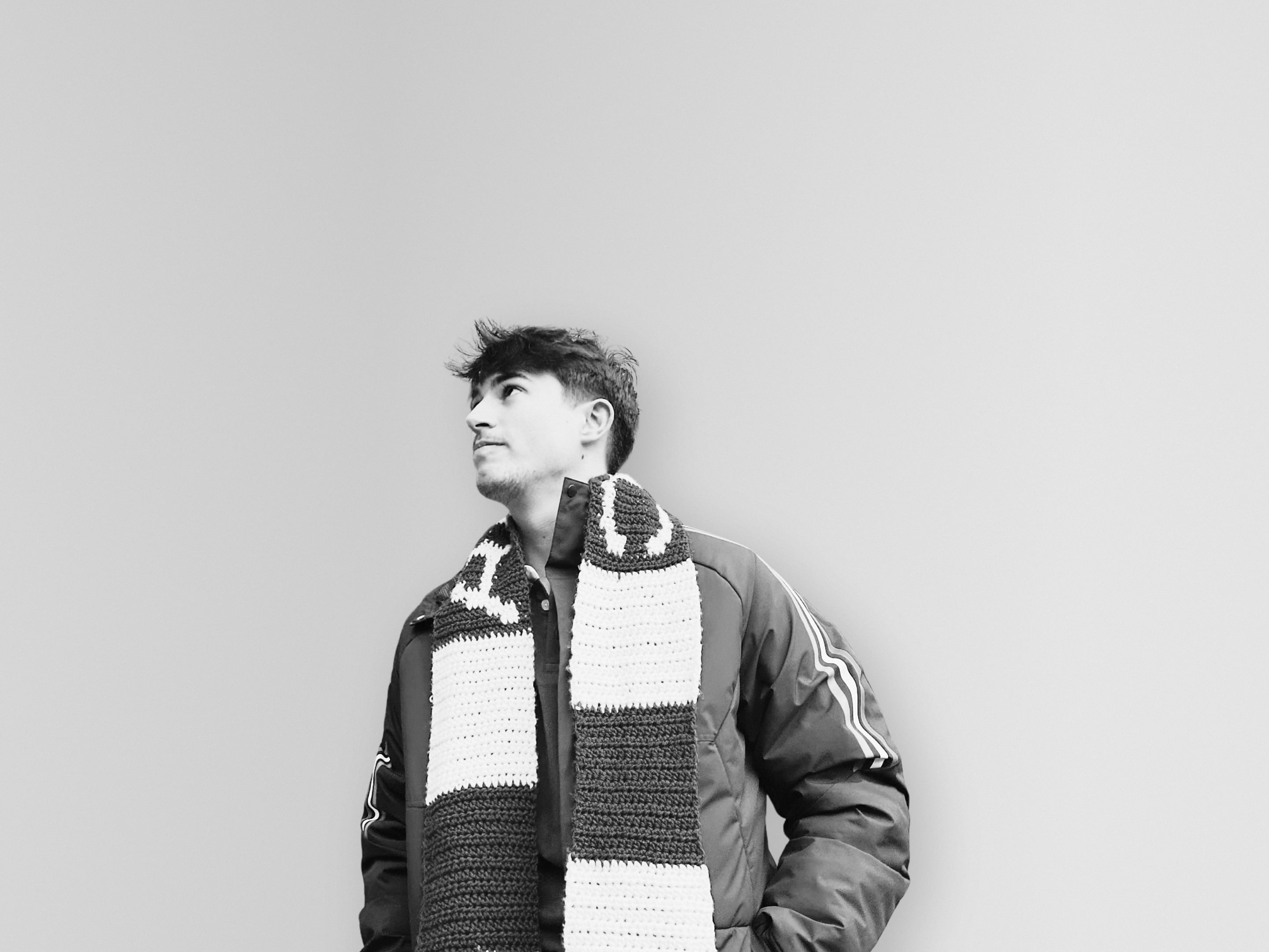 Black and white portrait of Pierre Potgieter in a striped scarf, looking up.